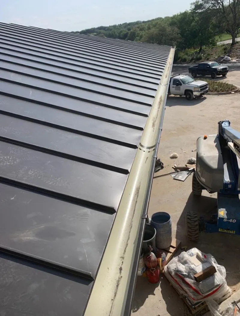 Standing seam panel and gutter detail on a metal roofing jobsite in Berea
